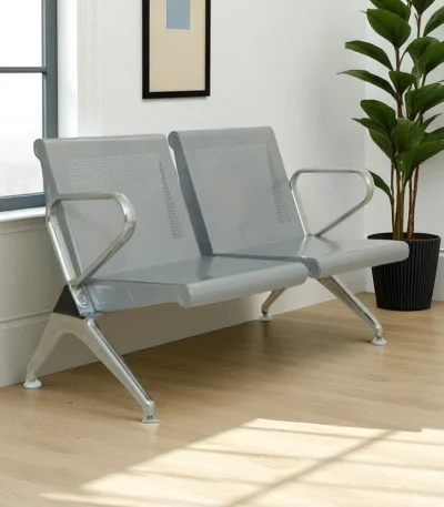 Grey powder-coated 2 seater steel waiting chair placed in a modern room with wooden flooring and indoor plant